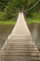 Fototapeta na wymiar Drewno most wiszący w lesie.