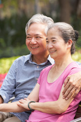 Naklejka premium Senior Chinese Couple Relaxing On Park Bench Together