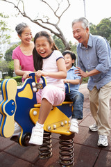 Chinese Grandparents Playing With Grandchildren In Playground