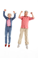 Obraz premium Studio Shot Of Chinese Senior Couple Jumping In Air