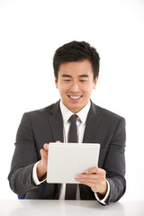 Studio Shot Of Chinese Businessman Working On Tablet Computer