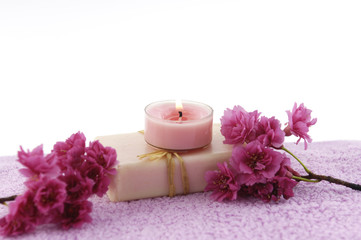 Fototapeta na wymiar Spa / bath towel and candle on soap with spring flower