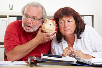 Senioren lauschen an Sparschwein