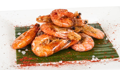 fried black tiger prawns with herbs and spices on banana leaf