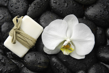 Fototapeta na wymiar Biała orchidea i mydła na kamyczki