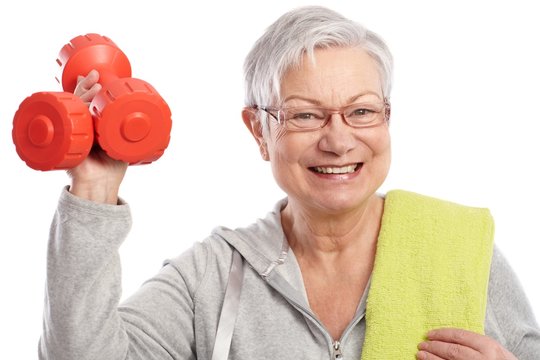 Energetic Elderly Woman With Dumbbells Smiling