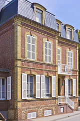Fototapeta na wymiar Piękny dom z cegły z białymi okiennicami w Etretat, Francja