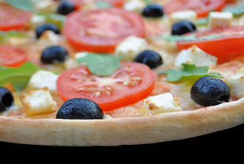 Pizza mit Feta, Tomaten, Oliven und Ruccola