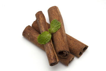 Sticks of cinnamon with mint and anise on a white background