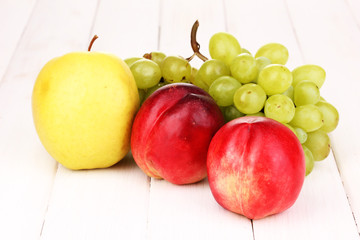 ripe sweet fruits and berries on wooden background
