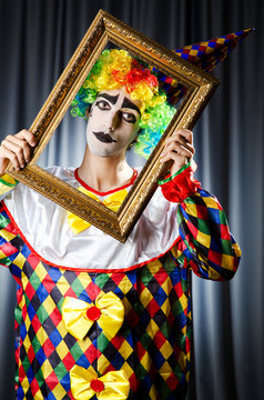 Clown with picture frames in studio