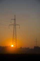 Fototapeta premium sunrise landscape with sun and utility pole