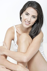 Naklejka premium Woman in white vest top sitting on sofa