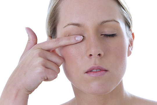 Femme se frotte l'oeil
