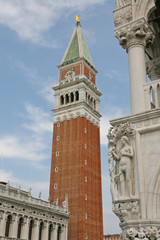 Fototapeta na wymiar Bell Tower of St Mark and a statue of the palazzo ducale