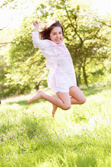 Young Girl Jumping In Summer Field