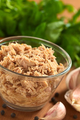 Tuna in glass bowl with garlic cloves and watercress