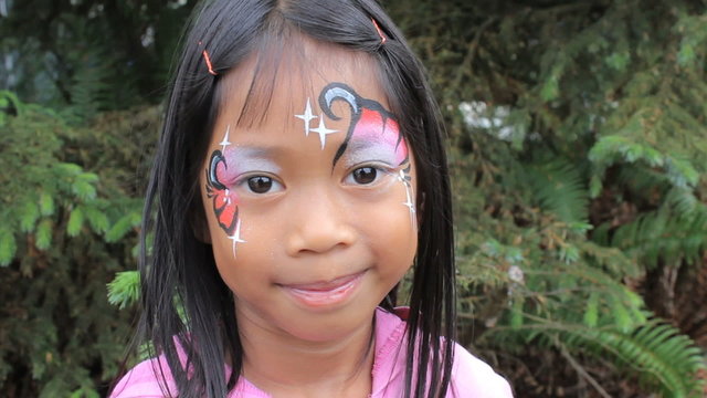 Cute Asian Girl Showing Off Her Face Paint Design