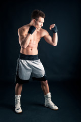 Fototapeta na wymiar Sportsman bokser intensywny portret w studio na czarnym backgro