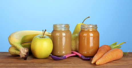 Jar with fruit and vegetables baby food, spoon and fruits and