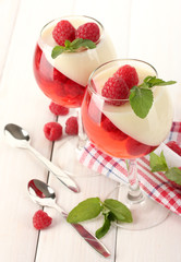fruit jelly with raspberries in glasses on wooden table