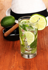 Mojito and a hat on a wooden background
