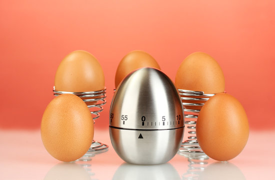 egg timer and eggs on red background