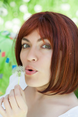 Summer portrait of the beautiful girl with a dandelion