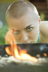 bald girl looks at fire