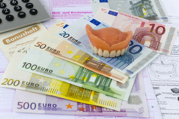 Zahnersatz, Euroscheine, Taschenrechner, Bonusheft