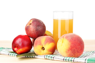 Ripe peaches and juice on wooden table on white background