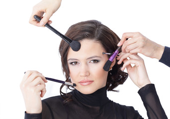 Obraz premium Beautiful woman with makeup brush near her face