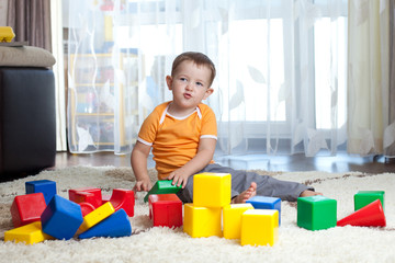 Child playing with building blocks at home.