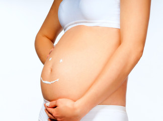 pregnant young female with cosmetic cream