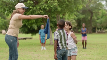 Children and teacher playing games in city park