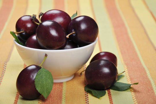 plums in white bowl