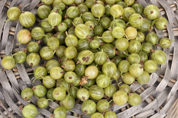 Green gooseberry on wicker mat close-up