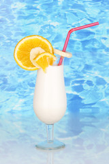 Delicious milk shake with fruit on table on blue sea background