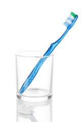 Toothbrush in glass and chewing gum isolated on white