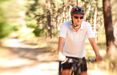 Man  on the bike in the sunny forest
