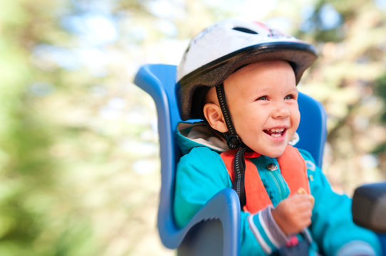 Little boy in bike child seat happy laughing