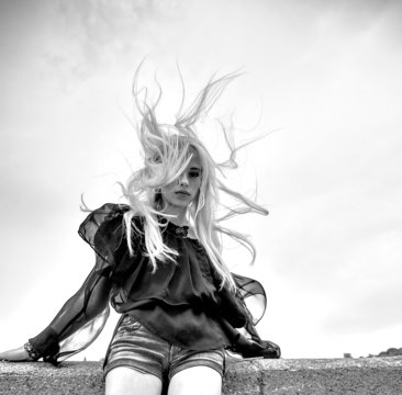 Beautiful blond women wind near water