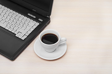 laptop with fresh cup of coffee and notebook