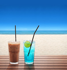 ice coffee with blue soda with lime on the summer beach