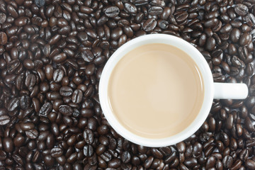 a cup of coffee on top view with coffee beans background