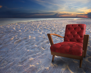 Fototapeta na wymiar red armchair on sand beach