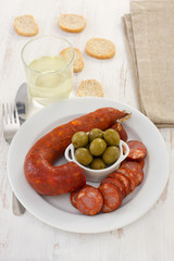 sausages with olives on the white plate