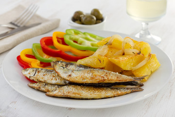 fried sardines with potato and glass of wine