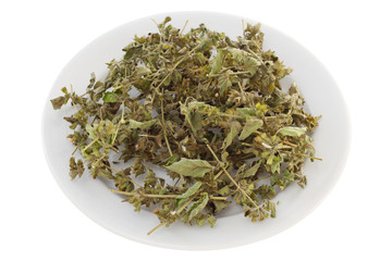 dry herb melissa on the white plate