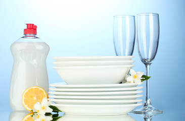 empty clean plates and glasses with dishwashing liquid and